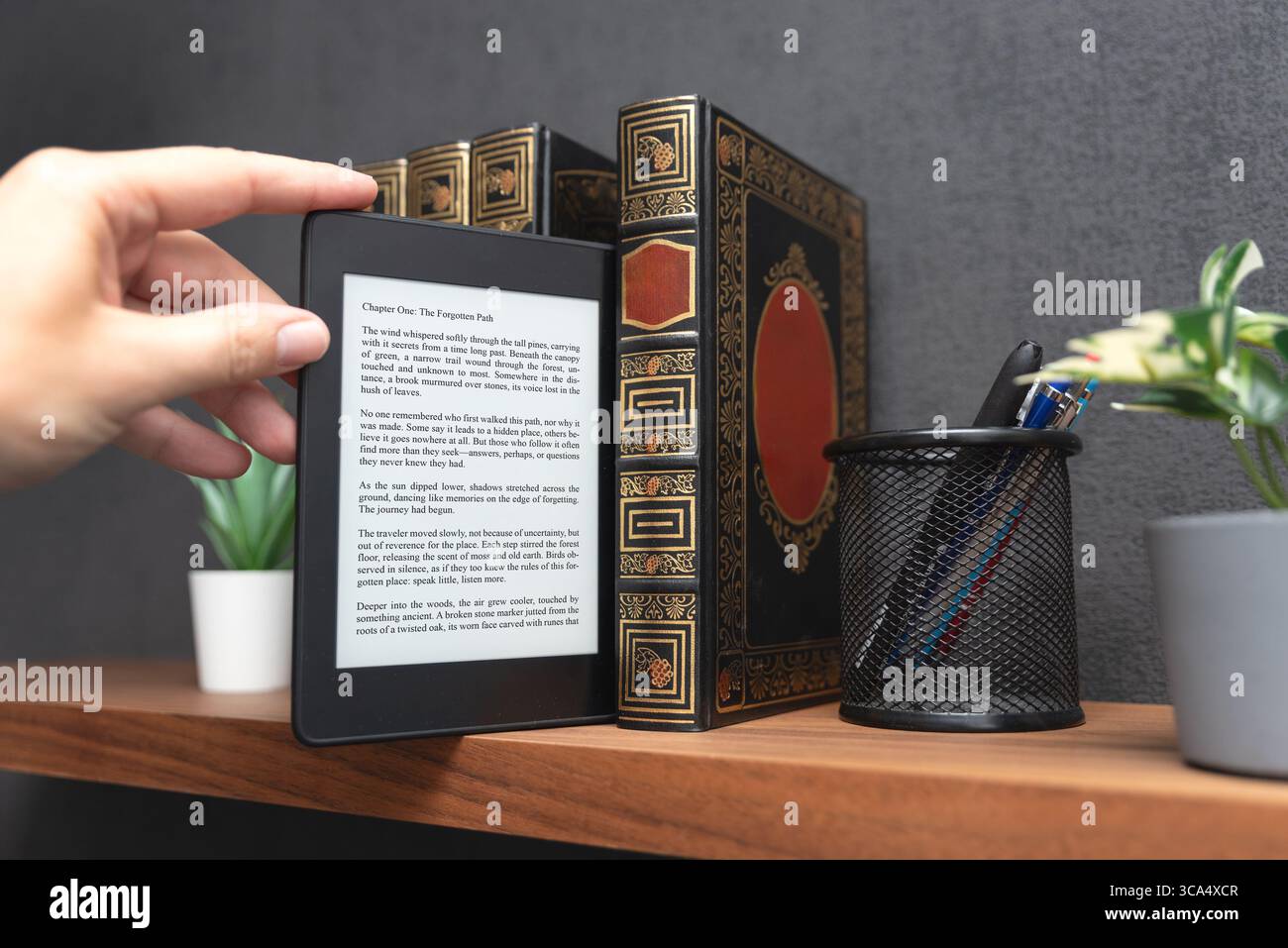 E-book reader device on shelf in home library Stock Photo