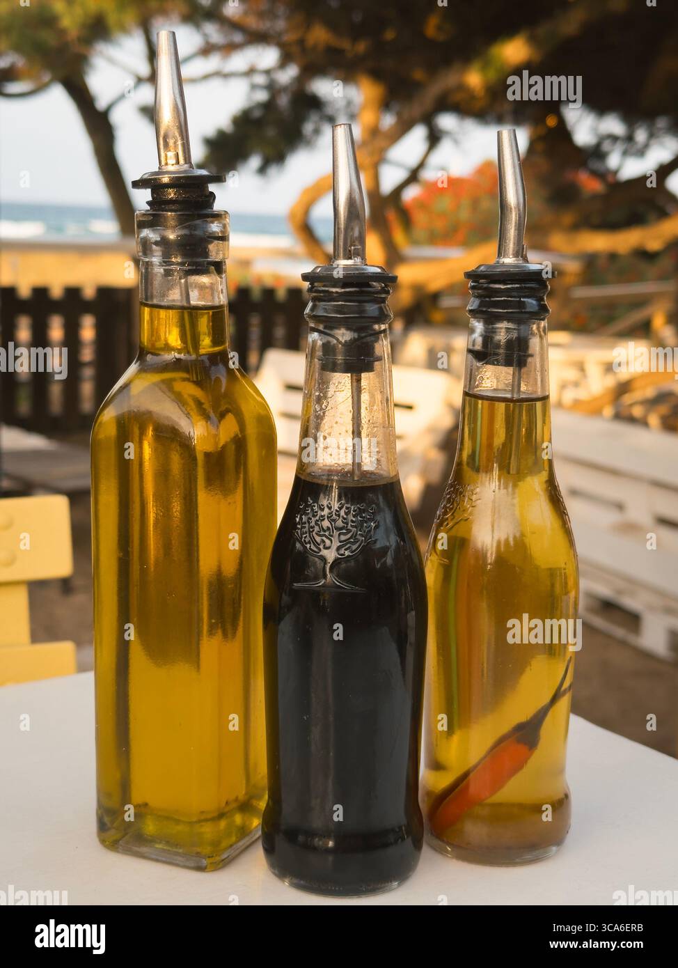 Olive oil, balsamic vinegar, and chili oil on a seaside table at a beach restaurant in Ibiza, Spain, capturing the essence of Mediterranean dining - Smartphone Captured Stock Image