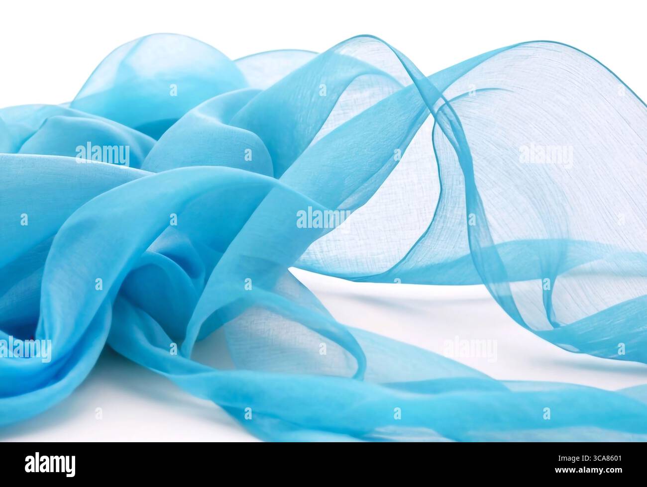 Transparent blue fabric draped in waves on white background Stock Photo