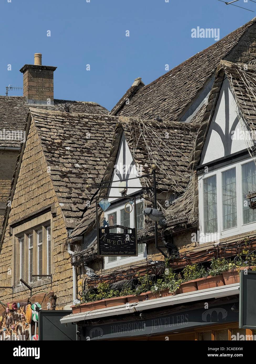 Traditional Cotswolds architecture in Bourton-on-the-Water, known for its honey-stone cottages and charming riverside setting. - Smartphone Captured Stock Image