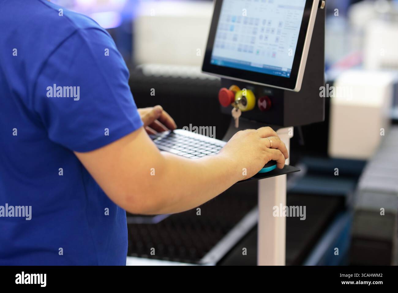 Operator working with industrial control console of computerized manufacturing machine. Selective focus. Stock Photo