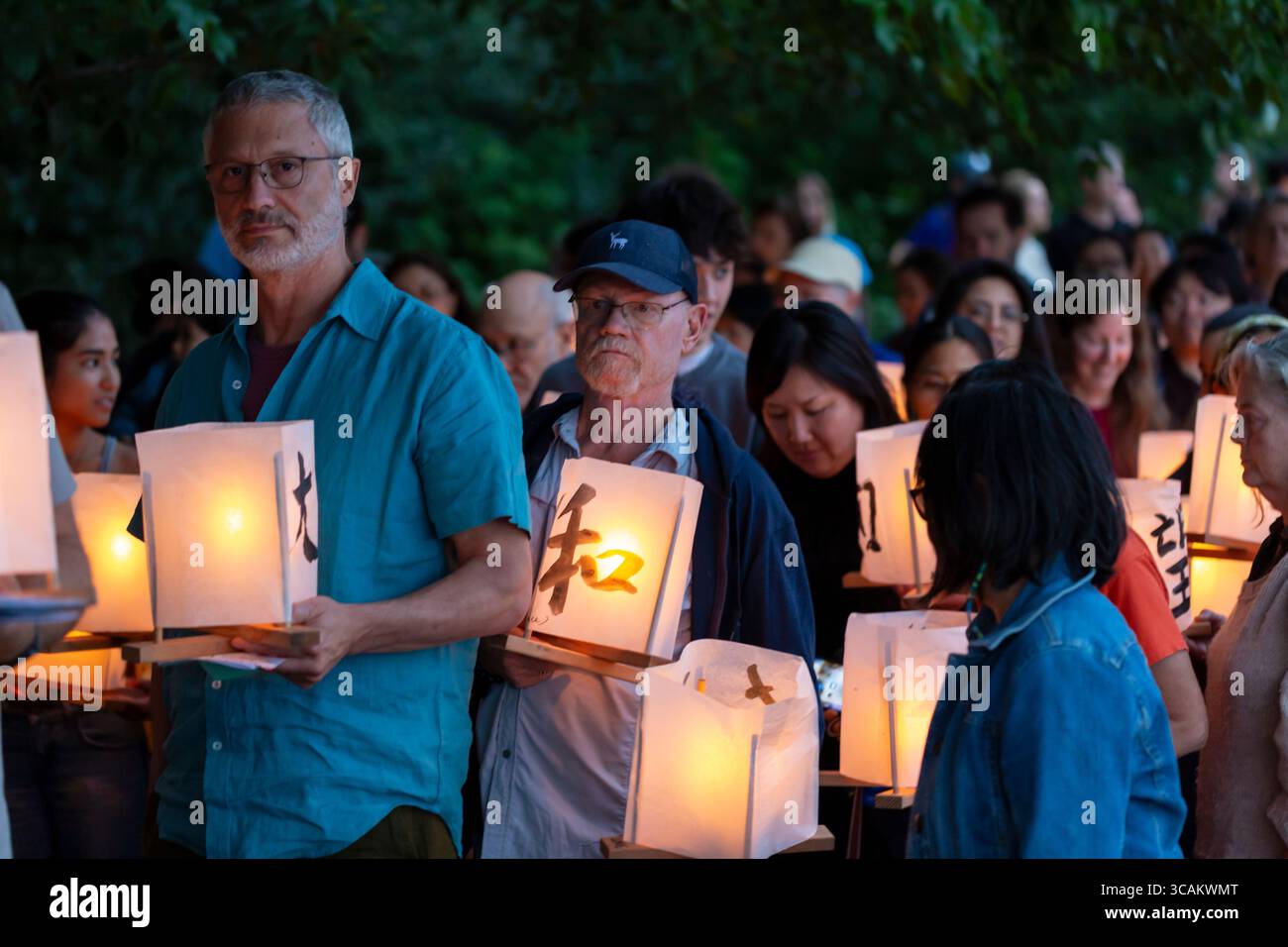 People gather with paper lanterns at the Toro Nagashi Lantern Floating Ceremony at Green Lake in Seattle on Wednesday, August 6, 2025. The annual cere Stock Photo