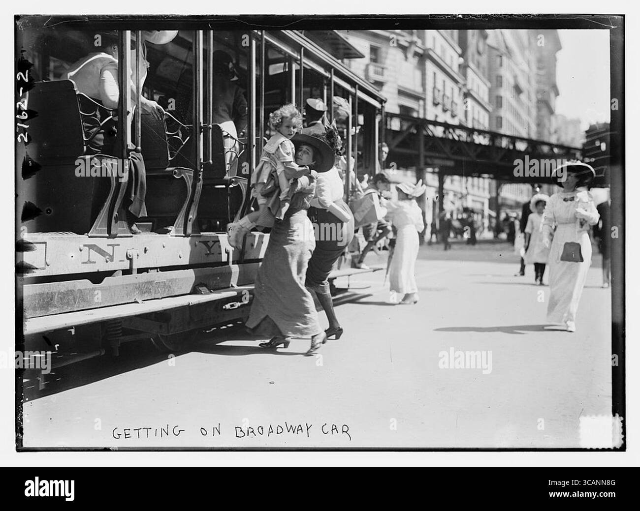 Getting on Broadway car at Herald Square. The Hotel McAlpin is shown in the background along with the elevated tracks of the Sixth Avenue El. - new york city 1900 Stock Photo
