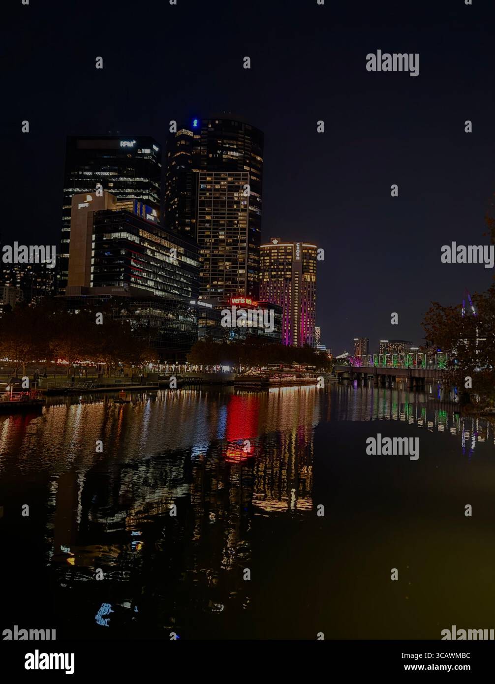 City skyline at night with illuminated buildings and colorful reflections on the Yarra River in Melbourne, Australia - Smartphone Captured Stock Image City skyline at night with illuminated buildings and colorful reflections on the Yarra River in Melbourne, Australia - Smartphone Captured Stock Image