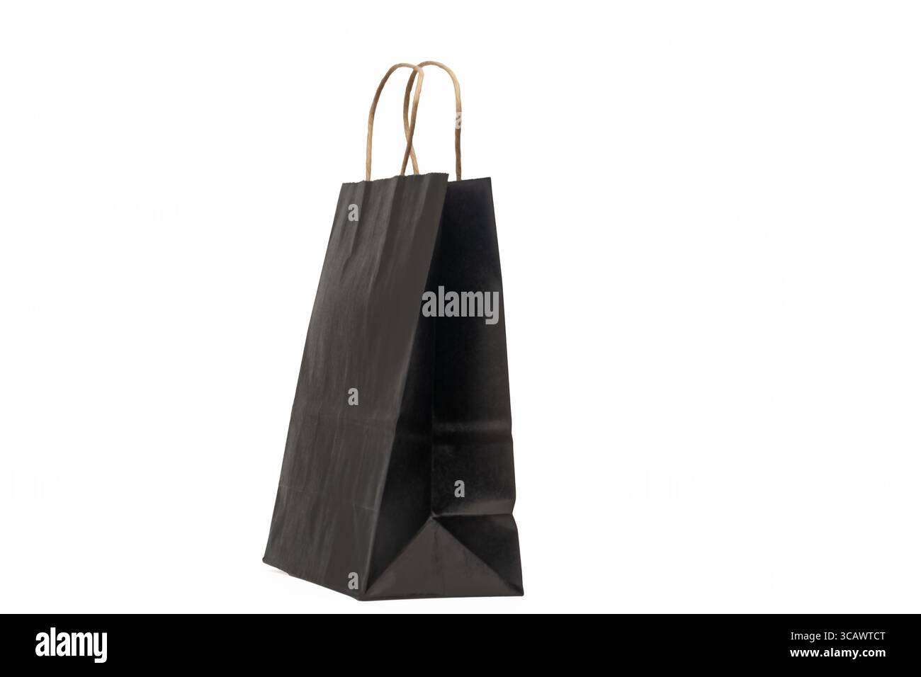 A sleek, isolated black paper shopping bag with sturdy brown kraft paper handles stands upright on a clean Stock Photo