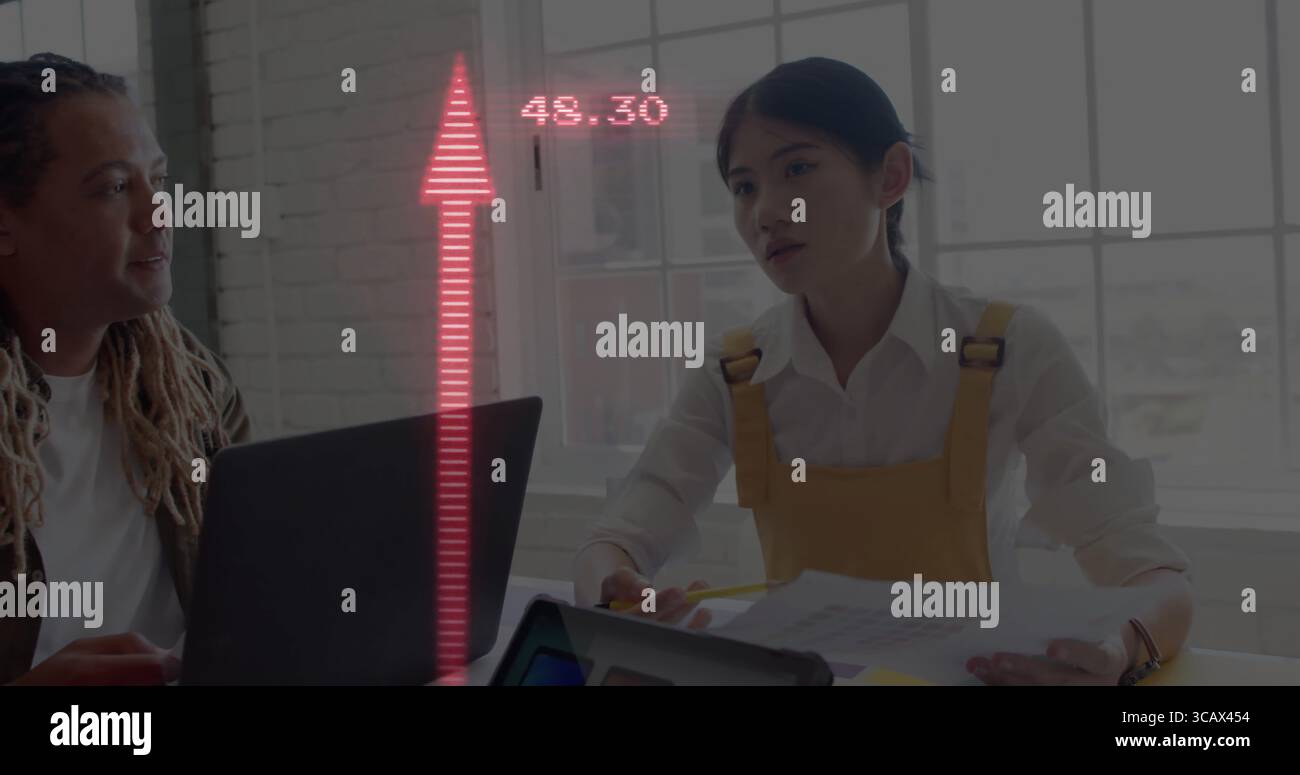Dreadlocked man and woman in yellow overall discussing data in office with laptop and documents Stock Photo