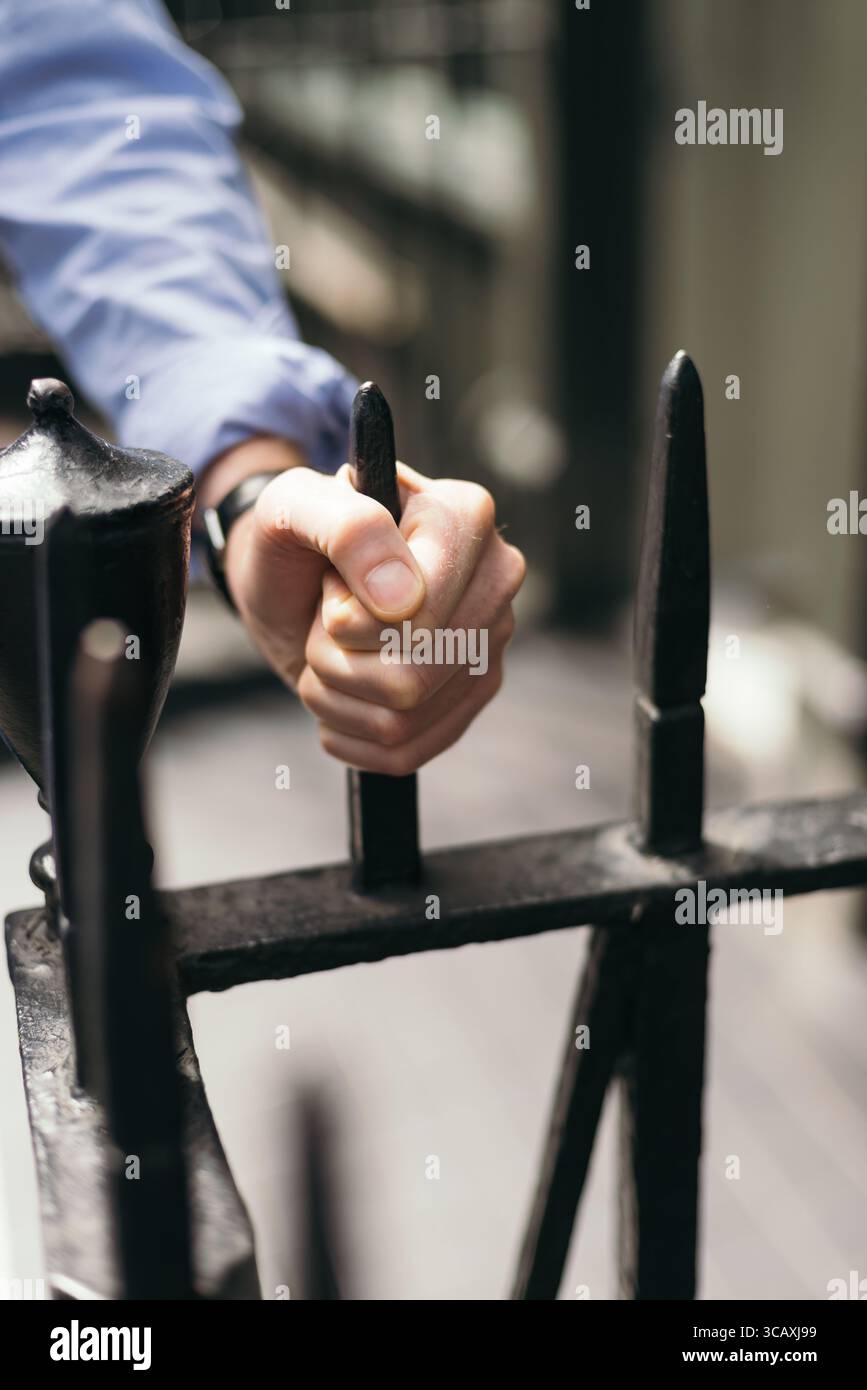 Grabbing Railing Man's hand grabbing wrought iron railing Stock Photo - Alamy