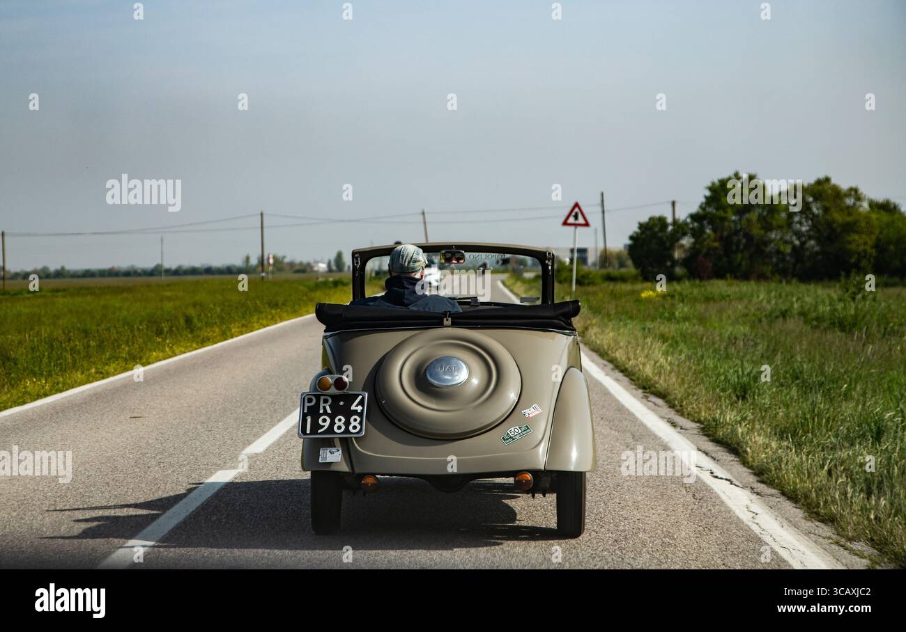Classic automobile on winding road historic architecture backdrop ...