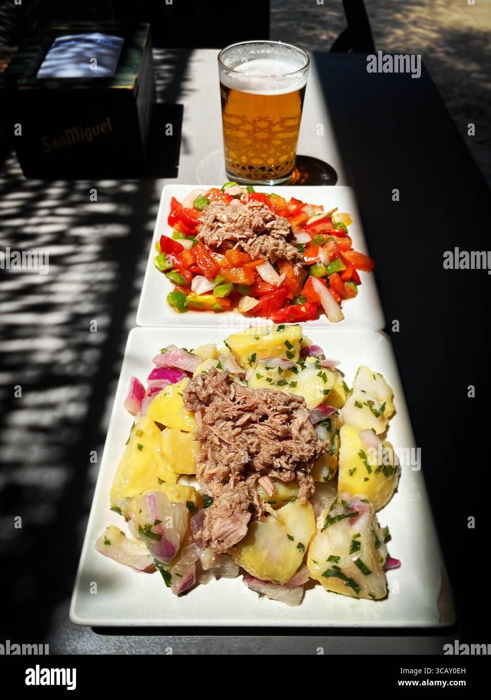 Dressed potatoes with melva fish, grilled red peppers and a beer in a restaurant in El Palmar, Vejer de la Frontera, Cadiz - Smartphone Captured Stock Image