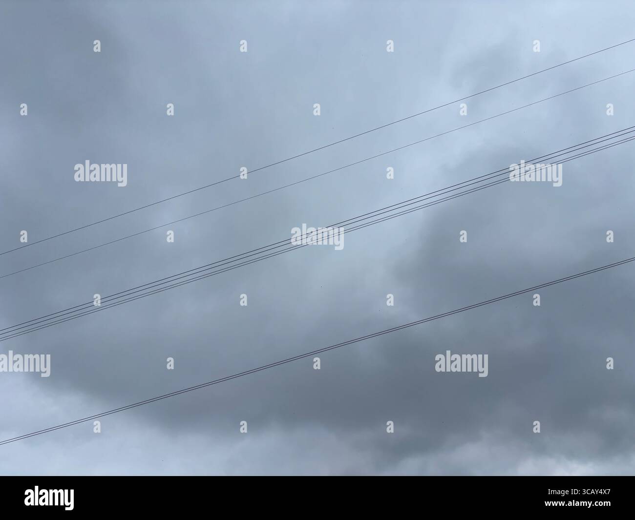 Electricity cables against dark clouds. - Smartphone Captured Stock Image