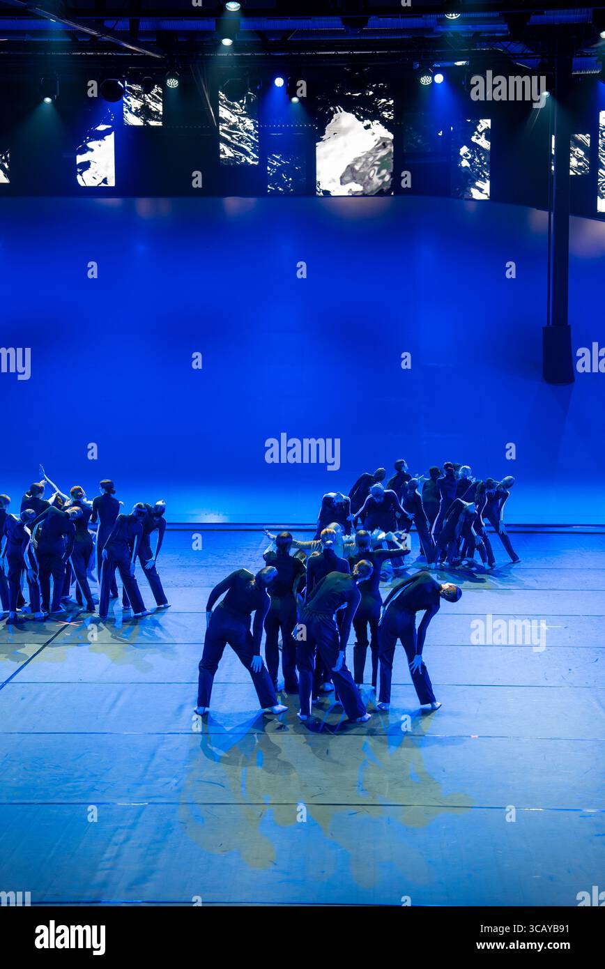 Young Dancers Perform on a Brightly Lit Stage with Blue Lighting Stock Photo