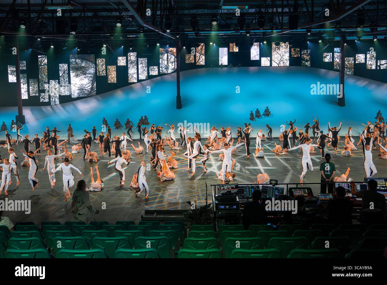 Synchronized Dance Performance on Stage with Blue Gradient Backdrop Stock Photo