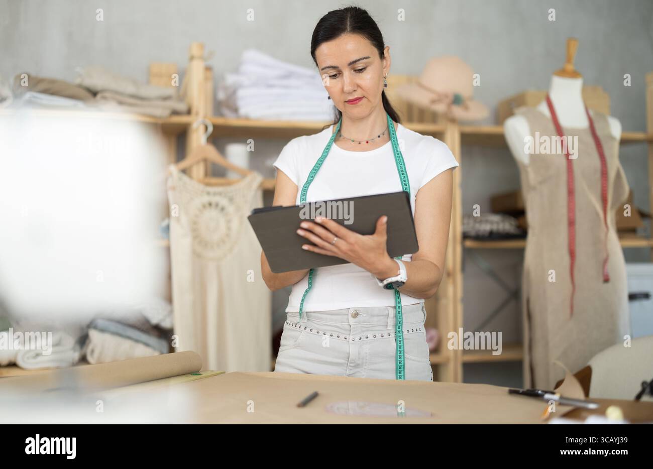 Woman dressmaker makes pattern using tablet Stock Photo