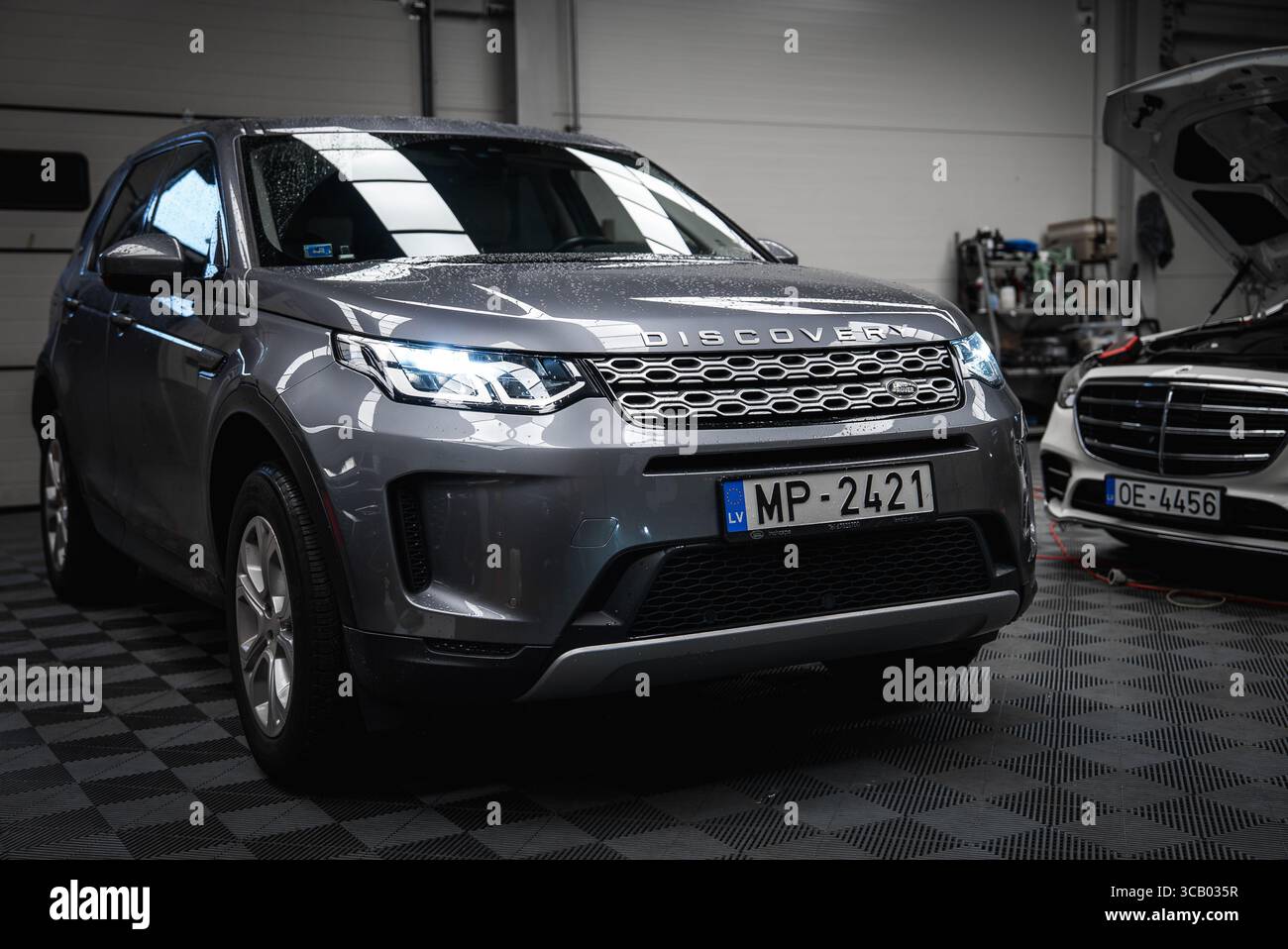 Silver Range Rover Discovery and Black Mercedes G Class in Garage Stock ...