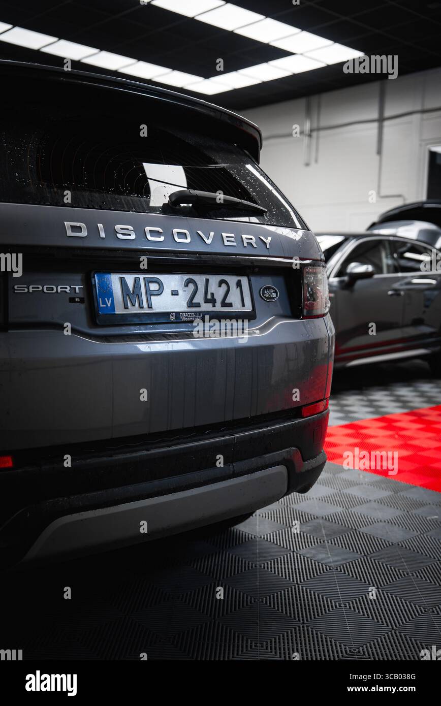 Rear View of Gray Land Rover Discovery Sport in Modern Garage Stock Photo