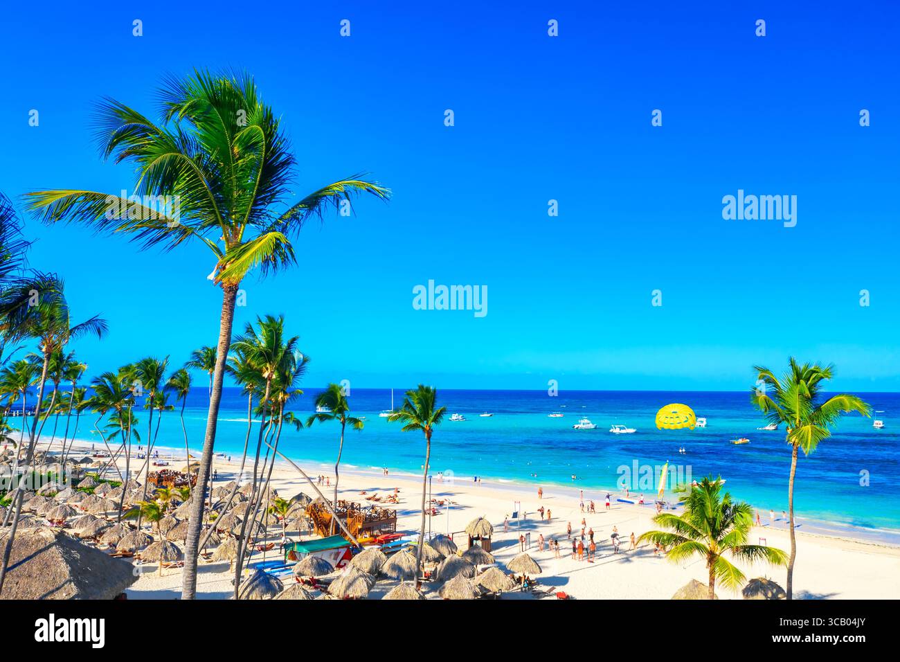 Beautiful atlantic tropical beach with palms, umbrellas and parasailing ...