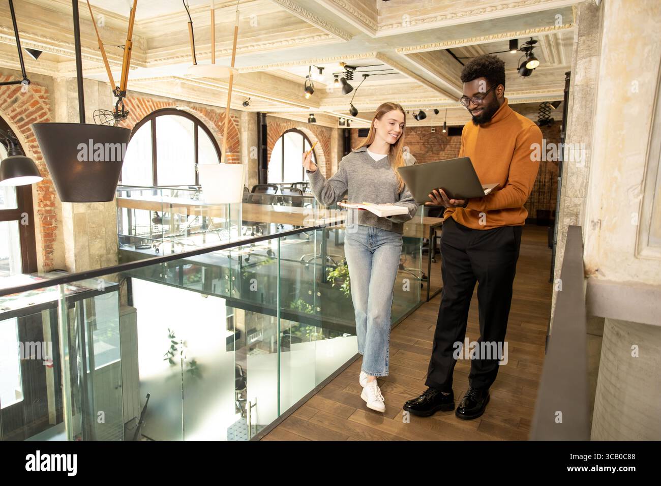 Multiethnic team members collaborating and smiling while working on business project Stock Photo