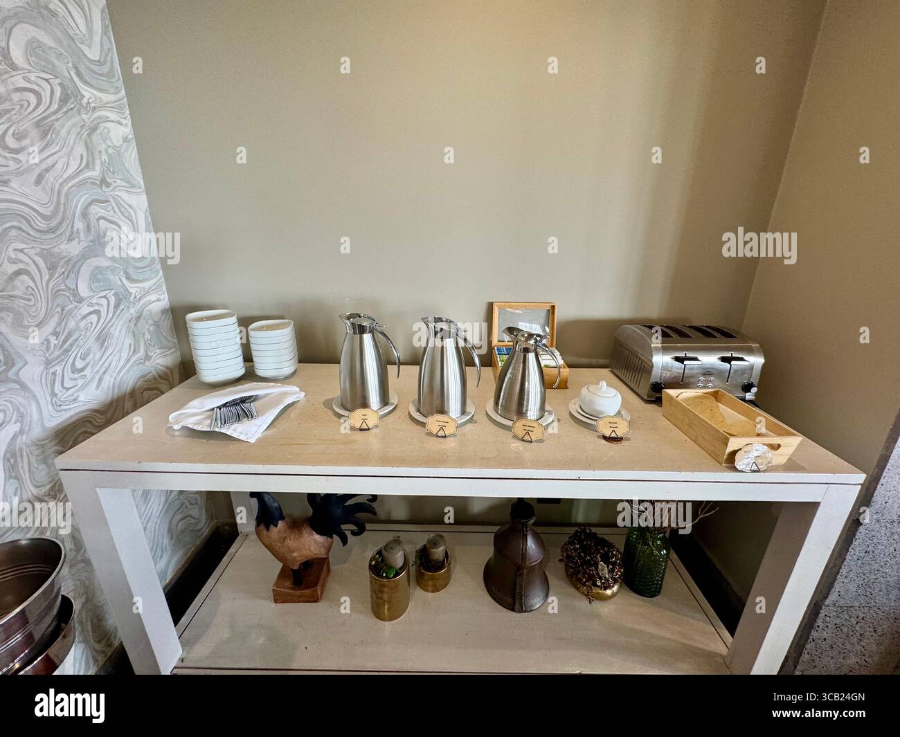 Beverage station with stainless steel coffee pots, cups, toaster, and condiments set on a modern table at Lince Nordeste Country Hotel. - Smartphone Captured Stock Image