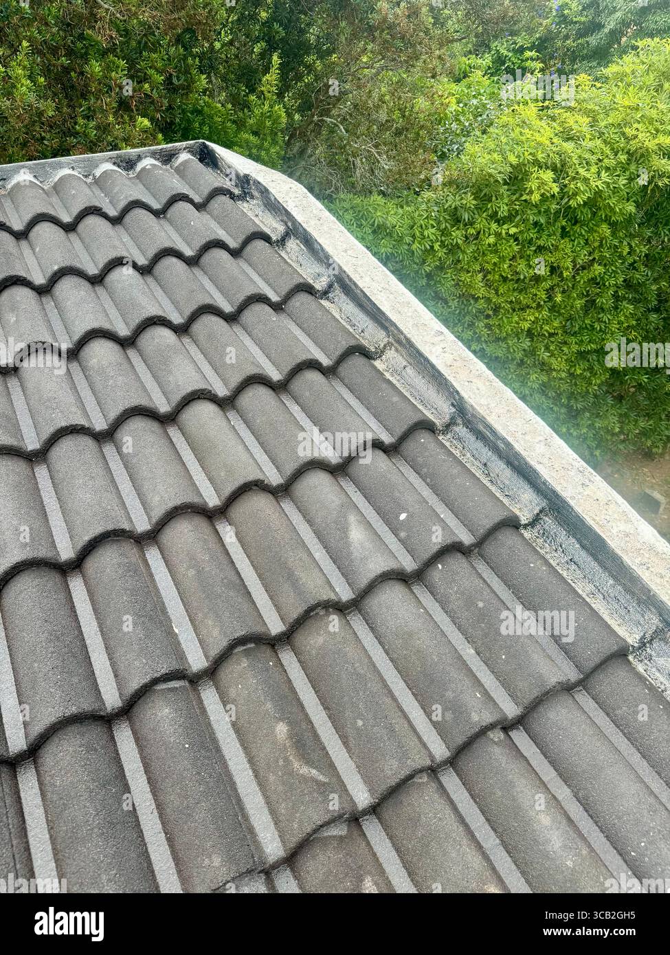 Cement tile roof with primer applied in preparation for waterproofing maintenance. - Smartphone Captured Stock Image