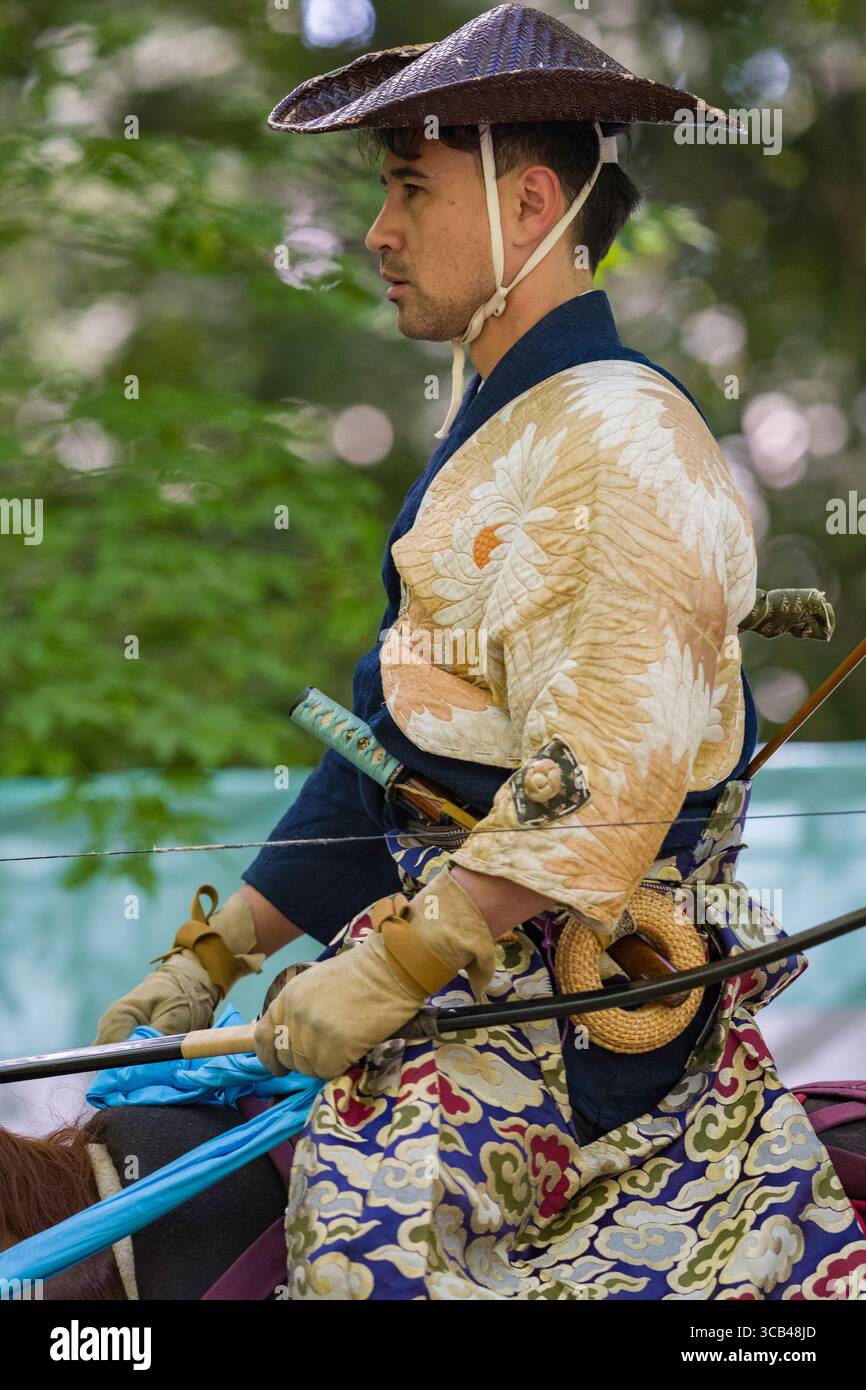 A skilled samurai dressed in traditional attire rides through a forest ...