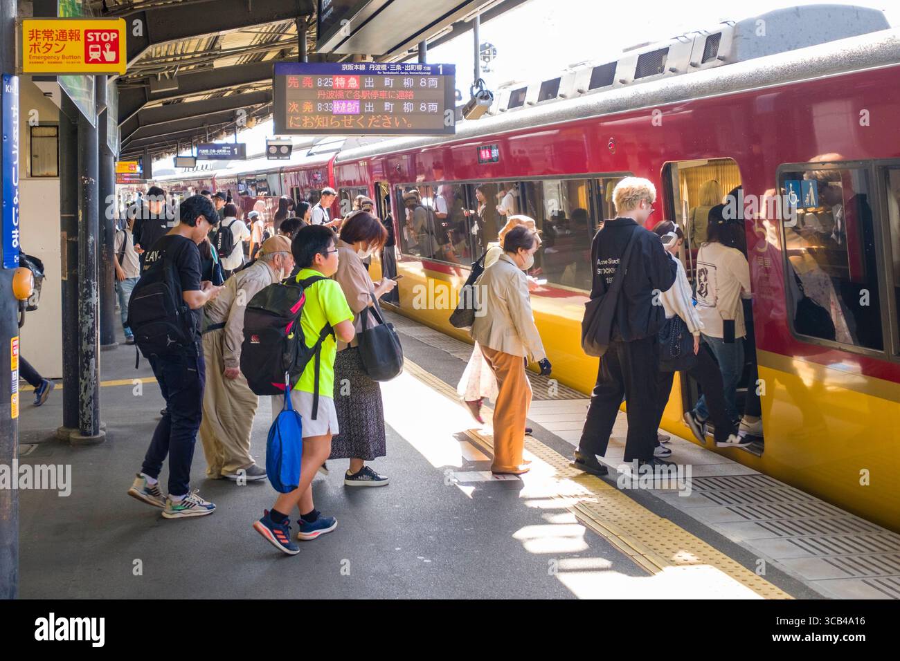 Passengers board a train at Chushojima Station platform, illustrating ...