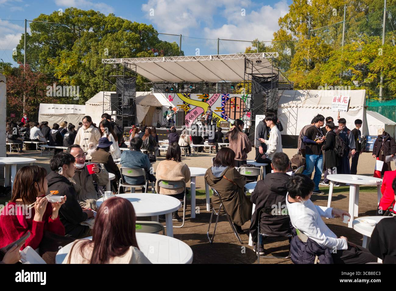 Kyoto University fall festival featuring live performances on a stage, attendees enjoying food, and community interactions in a festive atmosphere, su Stock Photo