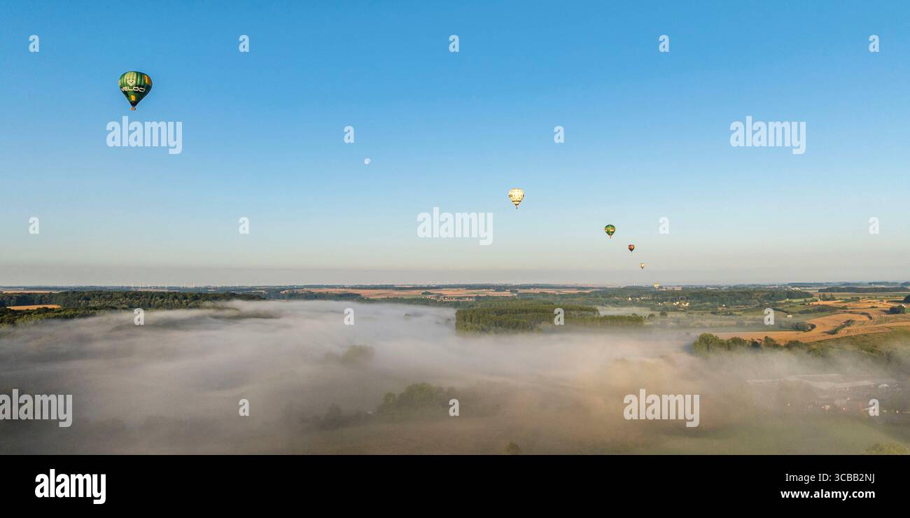 France, Somme, Baie de Somme, Saint-Valery-sur-Somme, arrival of hot-air balloons landing in a field after a flight over the bay in the morning mist (aerial view) Stock Photo