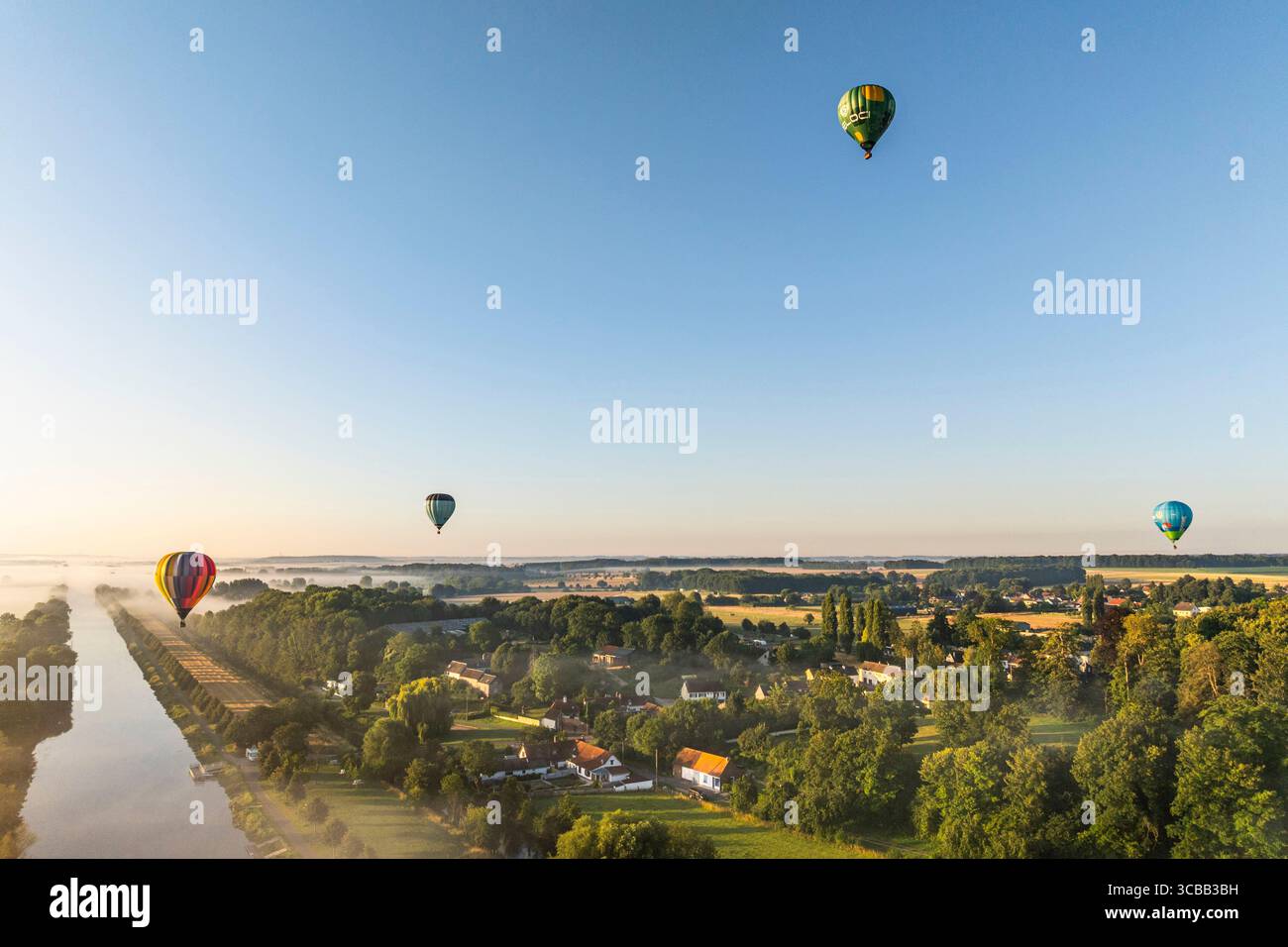 France, Somme, Baie de Somme, Saint-Valery-sur-Somme, arrival of hot-air balloons landing in a field after a flight over the bay in the morning mist (aerial view) Stock Photo
