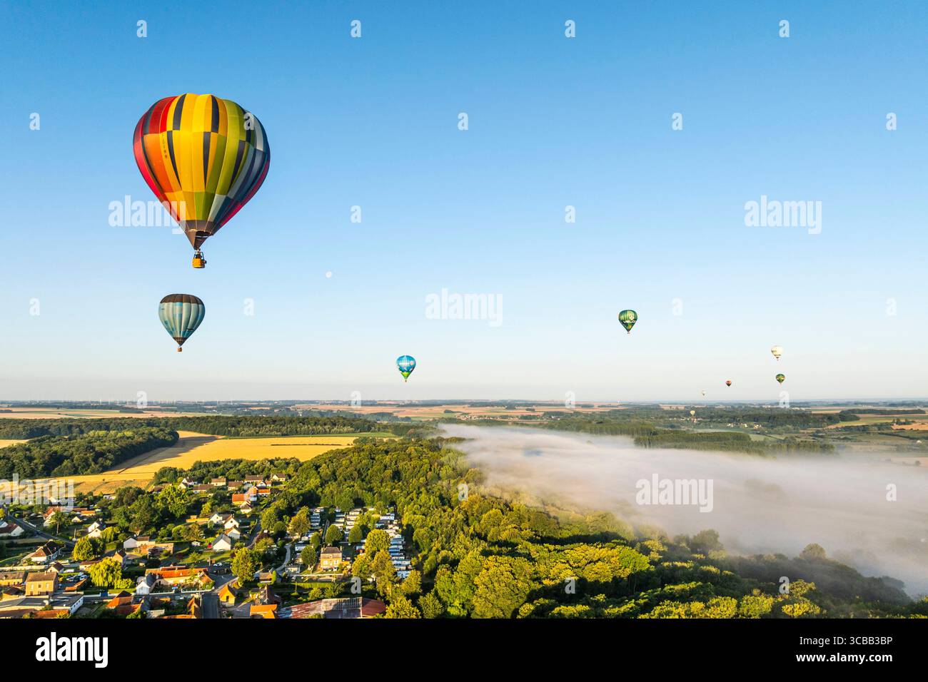 France, Somme, Baie de Somme, Saint-Valery-sur-Somme, arrival of hot-air balloons landing in a field after a flight over the bay in the morning mist (aerial view) Stock Photo