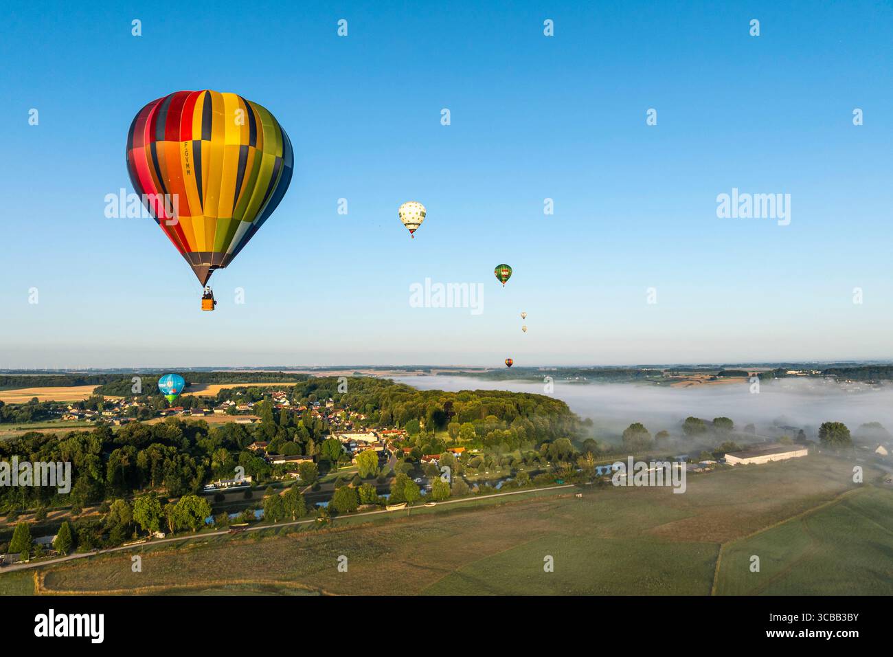 France, Somme, Baie de Somme, Saint-Valery-sur-Somme, arrival of hot-air balloons landing in a field after a flight over the bay in the morning mist (aerial view) Stock Photo