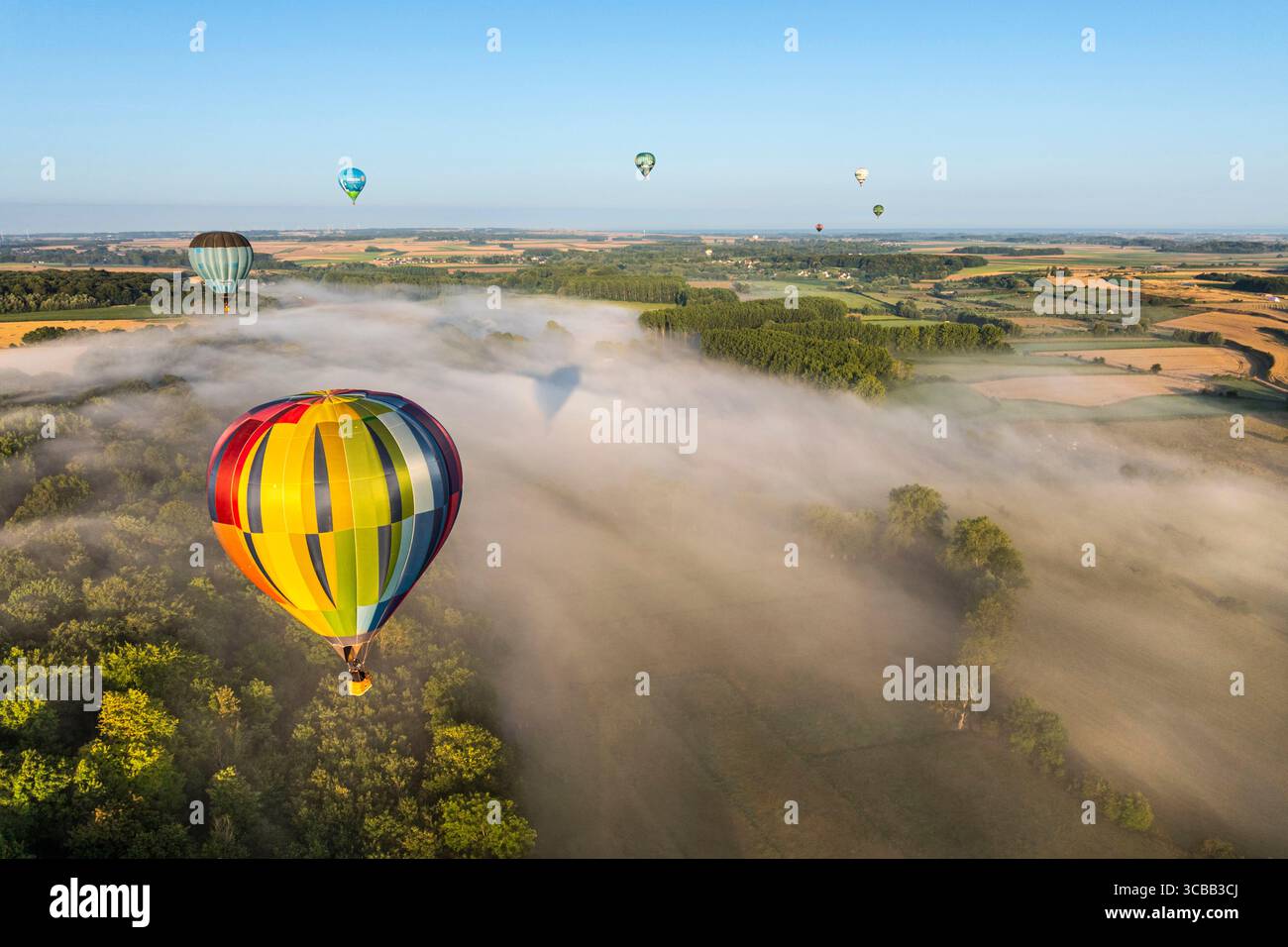 France, Somme, Baie de Somme, Saint-Valery-sur-Somme, arrival of hot-air balloons landing in a field after a flight over the bay in the morning mist (aerial view) Stock Photo