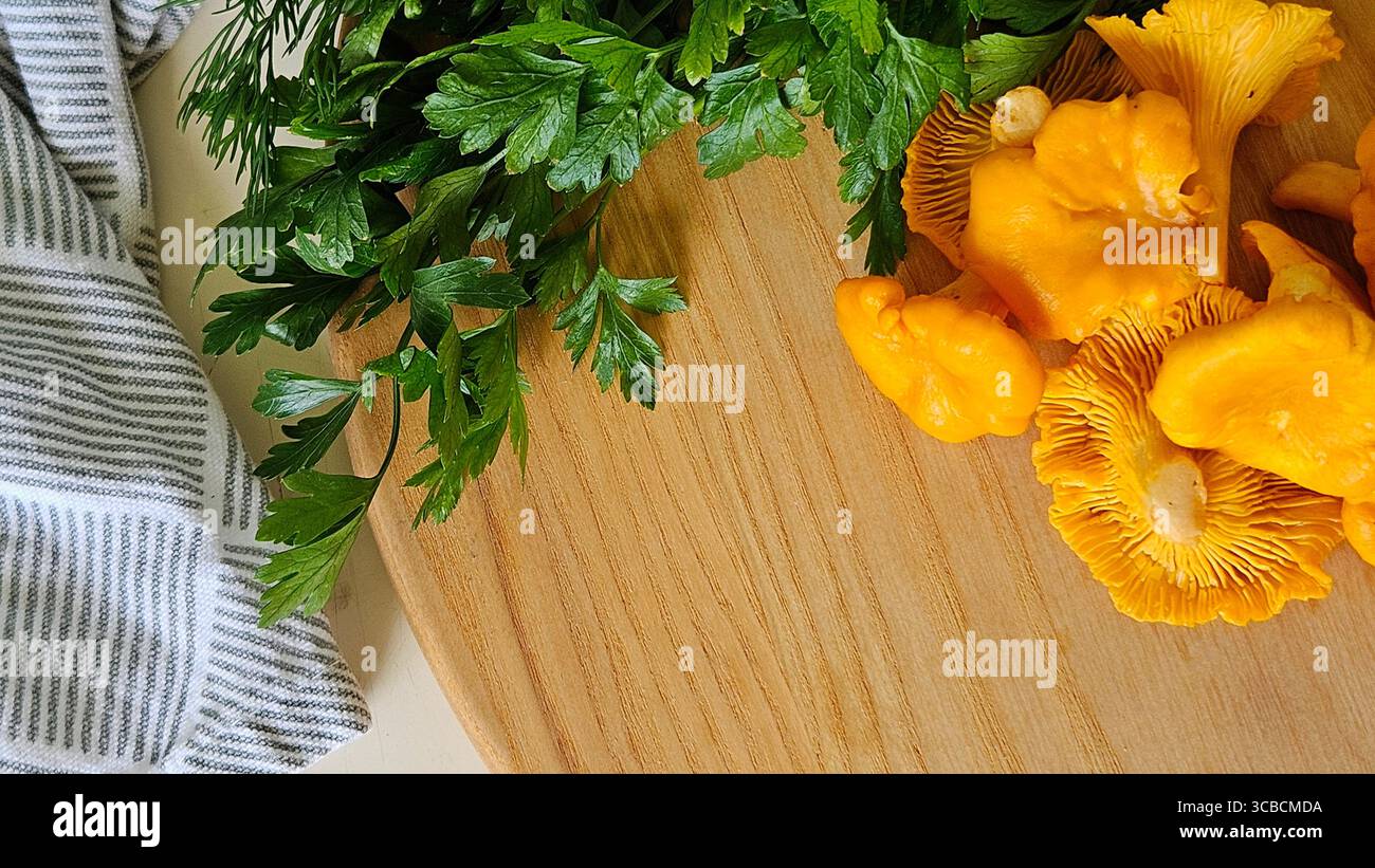 Fresh chanterelle mushrooms with parsley and dill on wooden board - Smartphone Captured Stock Image