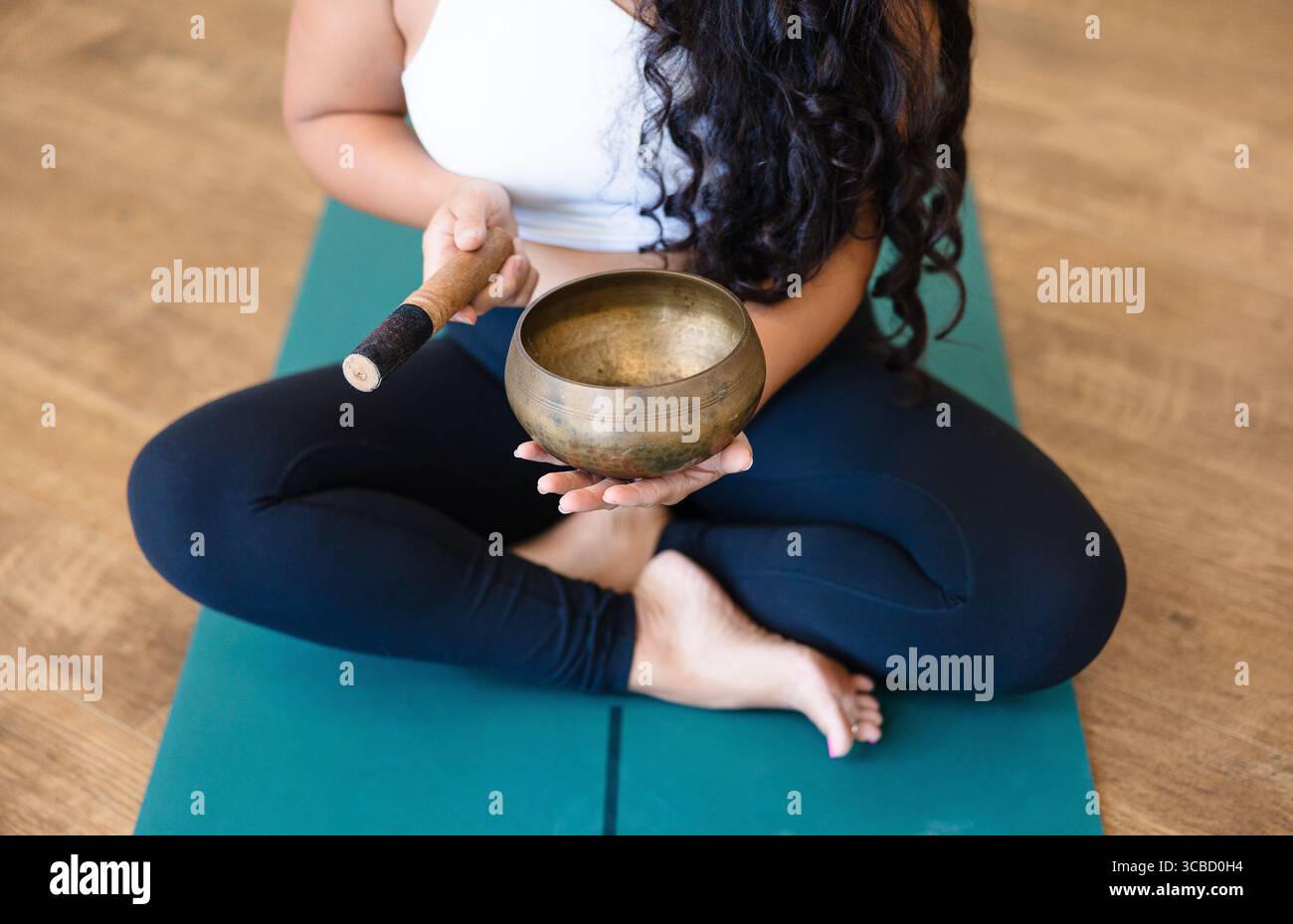 Woman Holding Tibetan Singing Bowl in Yoga Studio Stock Photo