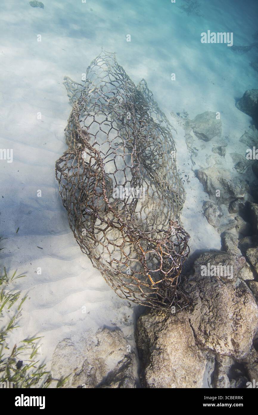 Metal cage lying on the bottom of the ocean Stock Photo