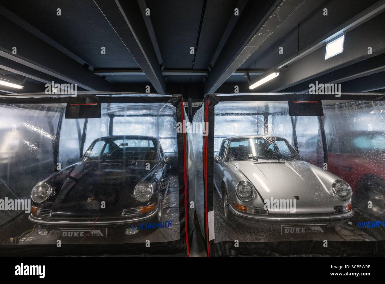 classic porsche in long-term vehicle storage, protected by a breathable plastic cover to prevent moisture buildup and preserve the car’s condition. Stock Photo