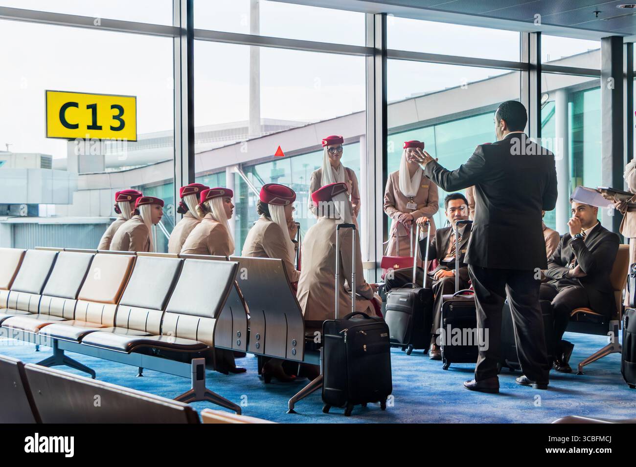 Emirates Airline crew in singapore Changi airport terminal gathered  team meeting & for pre-flight briefing near gate C13 Stock Photo