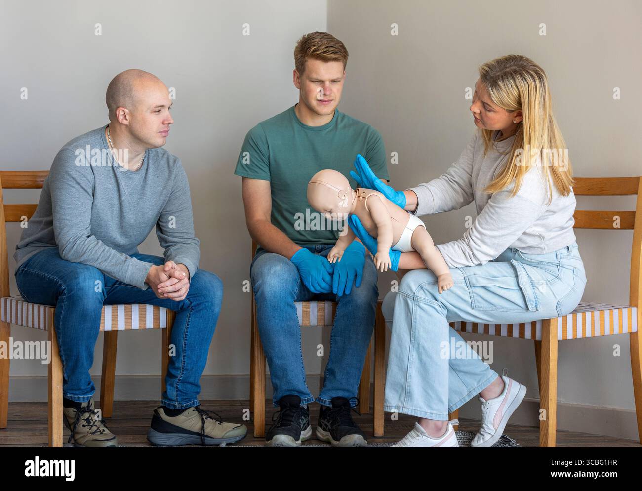 Female first aid instructor demonstrating the blockage release technique for infant choking by delivering back blows on an infant Basic Life Support ( Stock Photo