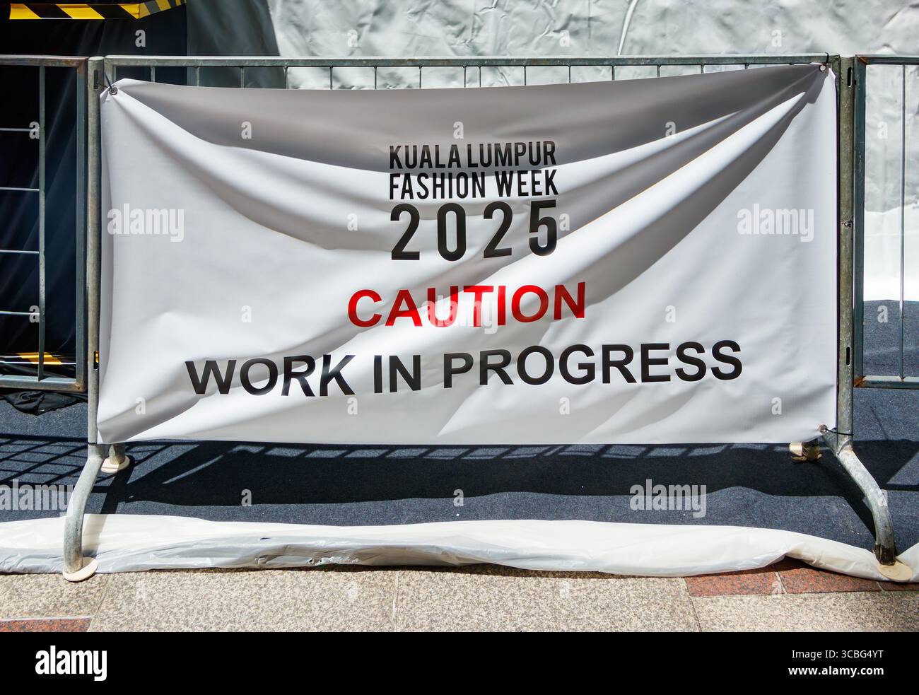 Caution sign on barrier for Kuala Lumpur Fashion Week 2025 showing work in progress at the event site Stock Photo
