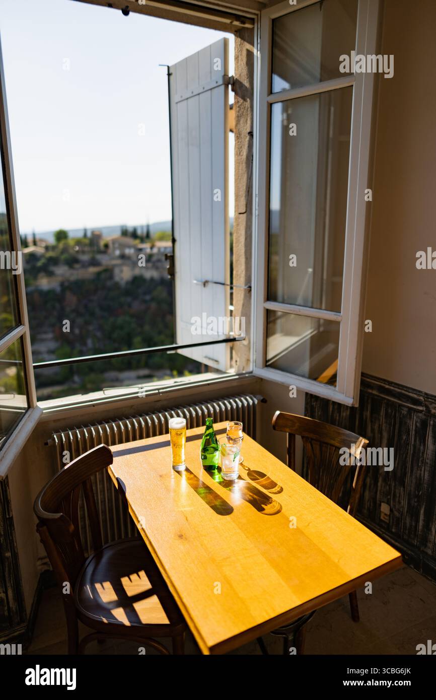 A cafe table with a view over the landscape around Gordes from a cafe window, Gordes, Luberon, Vaucluse, Provence-Alpes-Côte d'Azur, France Stock Photo