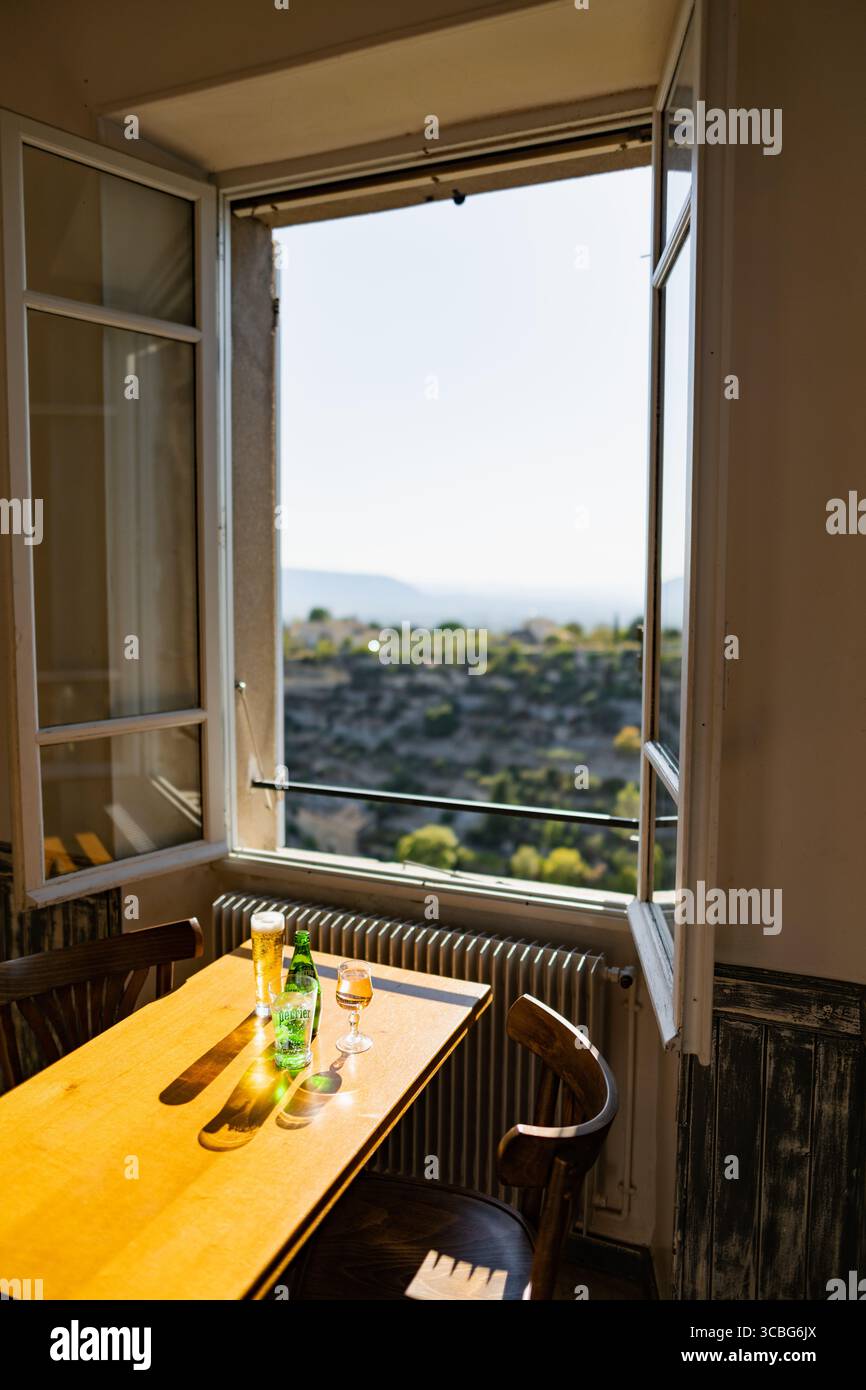 A cafe table with a view over the landscape around Gordes from a cafe window, Gordes, Luberon, Vaucluse, Provence-Alpes-Côte d'Azur, France Stock Photo