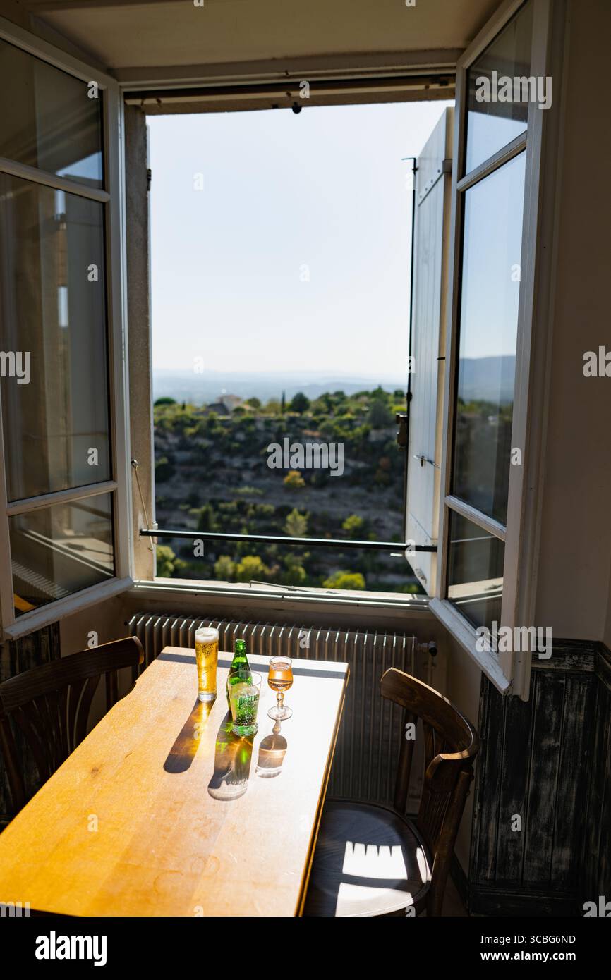 A cafe table with a view over the landscape around Gordes from a cafe window, Gordes, Luberon, Vaucluse, Provence-Alpes-Côte d'Azur, France Stock Photo