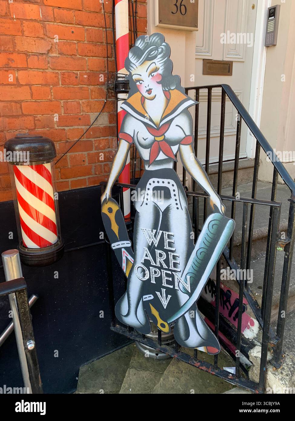 Super woman sign barbers hairdressers hairdresser signs outside stripes stripe hair haircut art wall art artistic rail pole barber cardboard cut-out - Smartphone Captured Stock Image