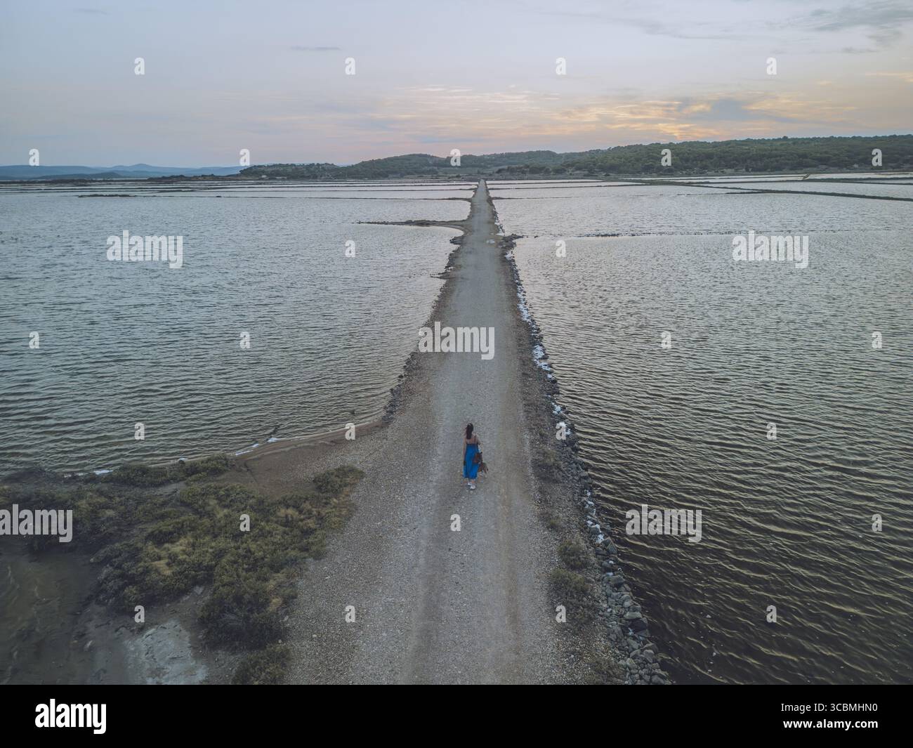Aerial view of a lone figure walking along a narrow path cutting ...
