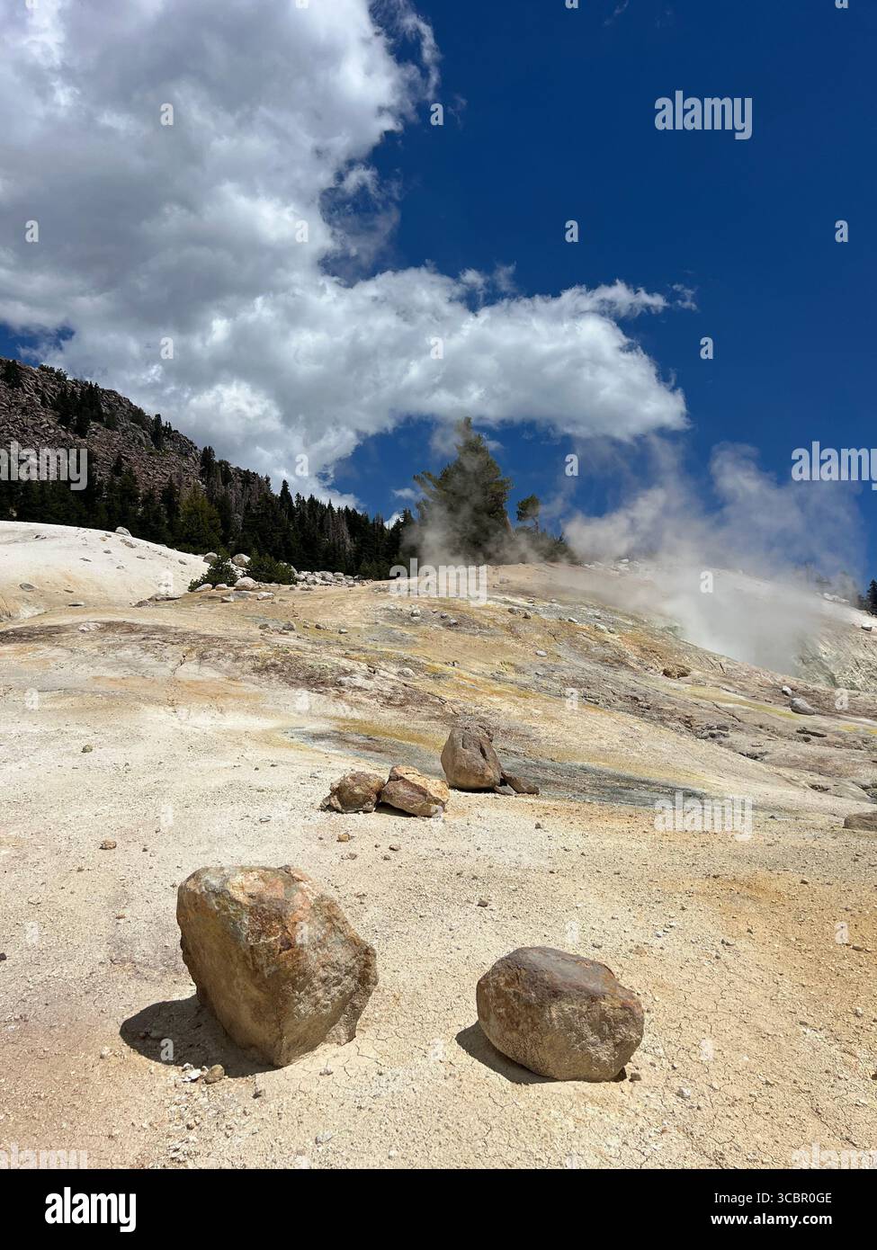 Two rocks in Bumpass Hell, Lassen Volcanic National Park, appear to roll across sulfur desert under a sky divided between deep blue and white clouds. - Smartphone Captured Stock Image Two rocks in Bumpass Hell, Lassen Volcanic National Park, appear to roll across sulfur desert under a sky divided between deep blue and white clouds. - Smartphone Captured Stock Image
