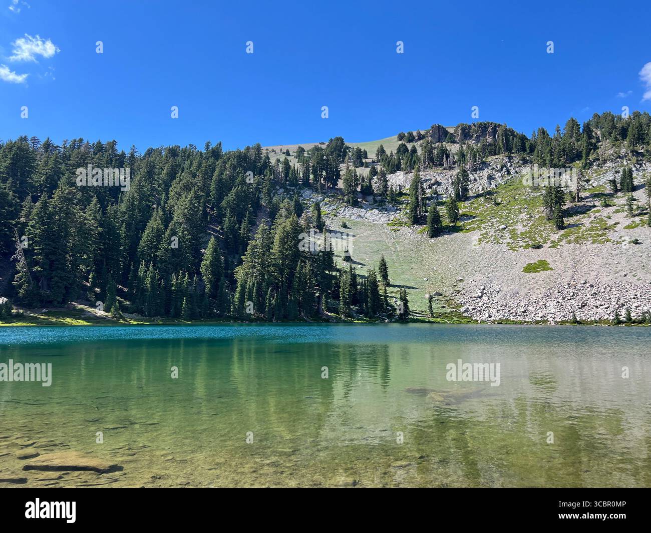 Emerald Lake, Lassen Volcanic National Park, California. Scenic alpine lake with clear green water, forested slopes, and deep blue summer sky. - Smartphone Captured Stock Image