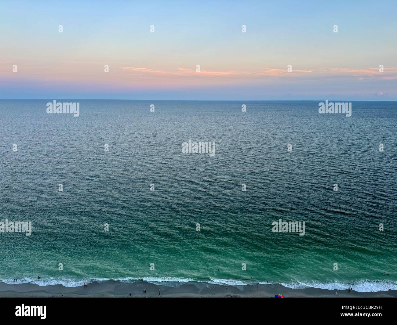 Soft illumination of wispy clouds over the Atlantic Ocean in South Carolina in the evening. - Smartphone Captured Stock Image