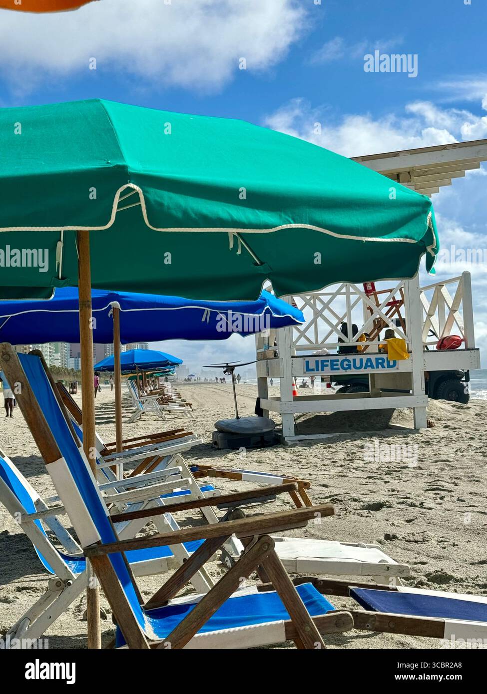 Umbrella with chair rentals are set up in a line each morning on Myrtle beach - Smartphone Captured Stock Image
