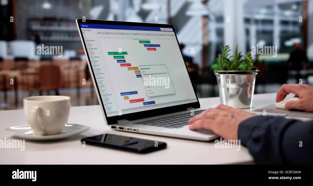 Man Using Scheduling Software To Manage Tasks And Report Progress Stock Photo