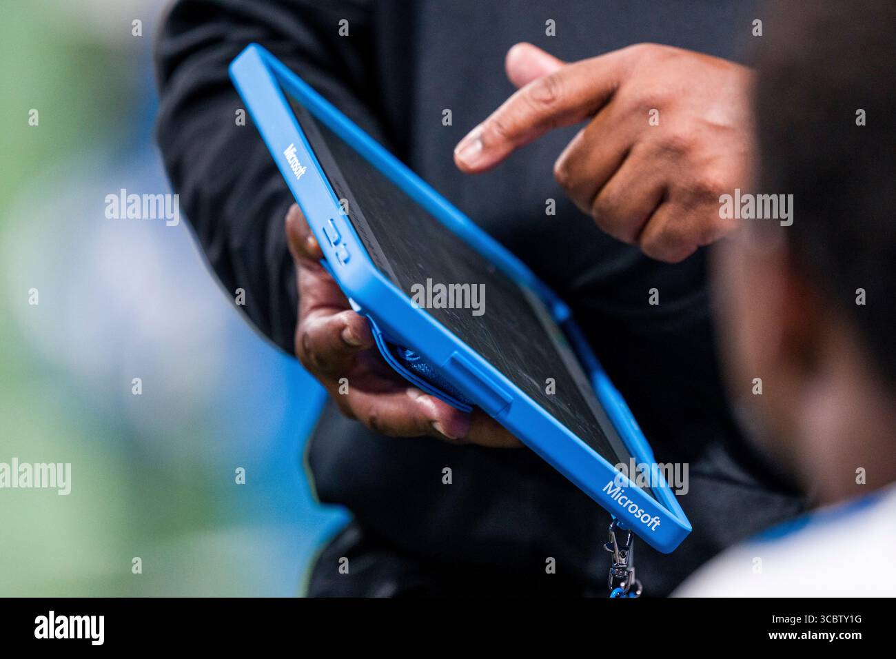 A Detroit Lions coach reviews plays using a Microsoft Surface tablet