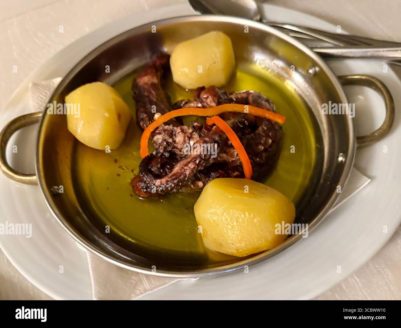 Traditional Portuguese octopus dish served with boiled potatoes and drizzled with olive oil. - Smartphone Captured Stock Image